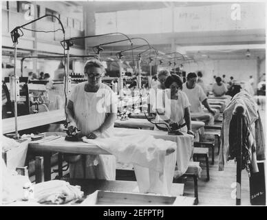 Ältere Frauen beim Bügeln in der Wäsche, wo die allgemeine Anordnung gut ist, aber Frauen haben anscheinend keine Sitze (3904009716). Stockfoto