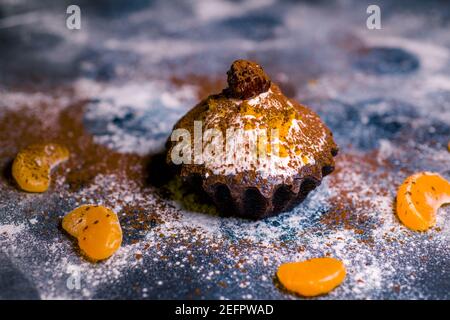 Schokoladen-Muffins bestreut mit Leckereien mit Kirschen und Schokolade und Kakao Stockfoto