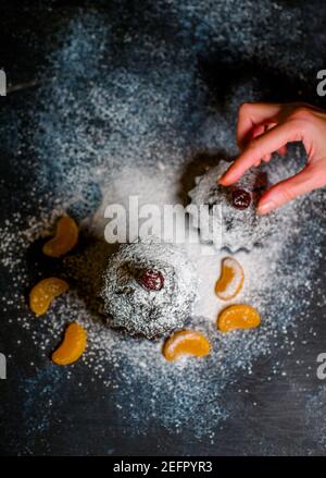 Schokoladen-Muffins bestreut mit Leckereien mit Kirschen und Schokolade und Kakao Stockfoto