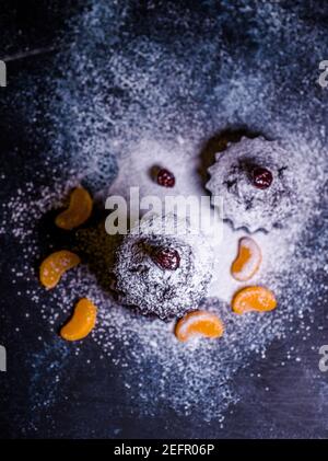 Schokoladen-Muffins bestreut mit Leckereien mit Kirschen und Schokolade und Kakao Stockfoto