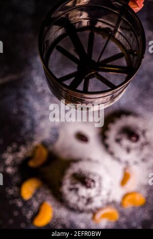 Schokoladen-Muffins bestreut mit Leckereien mit Kirschen und Schokolade und Kakao Stockfoto