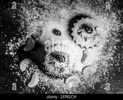 Schokoladen-Muffins bestreut mit Leckereien mit Kirschen und Schokolade und Kakao Stockfoto