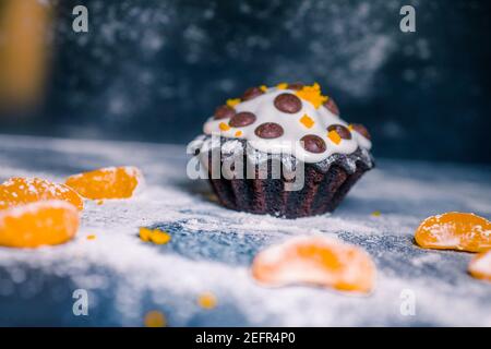 Schokoladen-Muffins bestreut mit Leckereien mit Kirschen und Schokolade und Kakao Stockfoto
