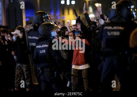 Madrid, Spanien. Februar 2021, 17th. Zahlreiche junge Demonstranten heben ihre Hände und schreien vor einer Reihe von Polizisten während einer Demonstration gegen die Verhaftung des Rappers Hasel. Ein Gericht hatte den in Spanien für seine manchmal radikalen Texte bekannten Musiker zu neun Monaten verurteilt, weil er die königliche Familie beleidigt und Gewalt in seinen Texten verherrlicht hatte. Während der Kundgebungen kam es zu Zusammenstößen zwischen Demonstranten und Polizei. Kredit: Juan Carlos Rojas/dpa/Alamy Live Nachrichten Stockfoto