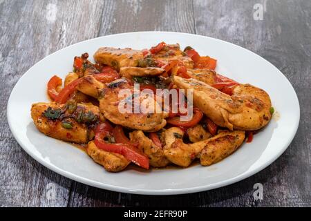 Hähnchen unter Rühren mit roten Paprika, Kohl und Zwiebel braten Stockfoto