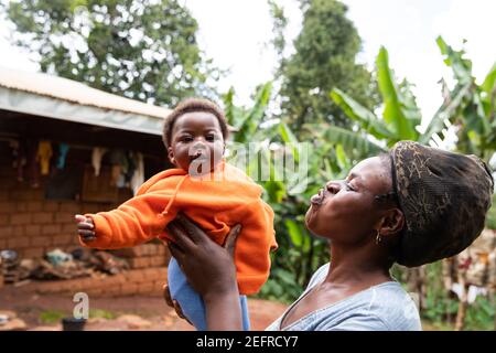 Afrikanische Mutter spielt mit ihrer neugeborenen Tochter, süßer Moment zwischen Mutter und Tochter Stockfoto