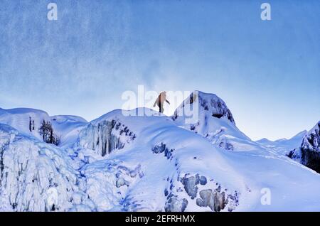 Die Figur einer Person auf der Spitze der gefrorenen Rutschen de Chaudière in Charny in der Nähe von Quebec City, Kanada Stockfoto