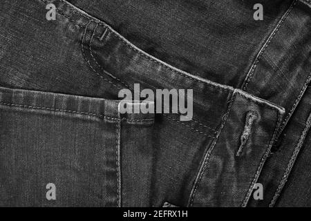 Schwarze Jeans-Qualität (Denim). Blick auf die Nähte der Beine und die Vorderseite der Hose. Stockfoto