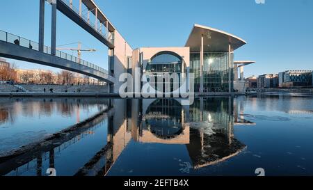 Pier Paul-Loebe-Haus Reichstag. Panorama-Winterblick von der Fußgängerbrücke über die Spree. Ruhiger Abend, Wasser mit Reflexionen, Eis auf Wasser Stockfoto