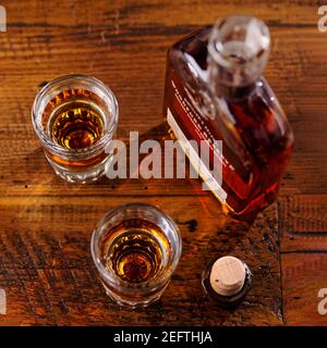 Kleiner bootle of Kentucky Strtaight Bourbon Whiskey mit Schnapsgläsern Auf einem rustikalen Holztisch Stockfoto