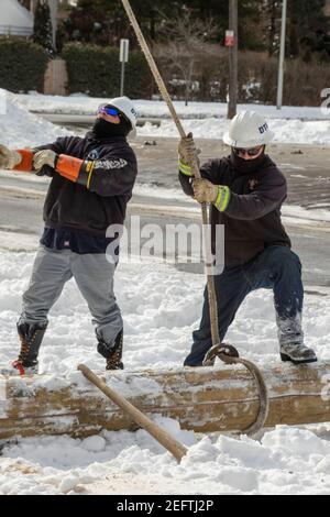 Detroit, Michigan, USA. Februar 2021, 17th. DTE Energy Workers, die bei bitterkaltem Wetter arbeiteten, bauten einen neuen Strommast auf, um einen Elektroservice für ein Wohngebäude bereitzustellen. Kredit: Jim West/Alamy Live Nachrichten Stockfoto