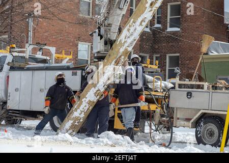 Detroit, Michigan, USA. Februar 2021, 17th. DTE Energy Workers, die bei bitterkaltem Wetter arbeiteten, bauten einen neuen Strommast auf, um einen Elektroservice für ein Wohngebäude bereitzustellen. Kredit: Jim West/Alamy Live Nachrichten Stockfoto