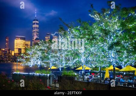 Restaurant Patio mit beleuchteten Bäumen mit Blick auf Lower Manhattan, Newport, Jersey City Stockfoto