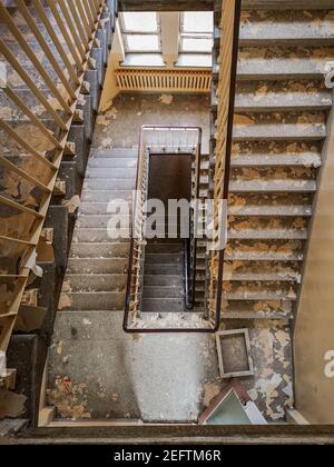 Schmutzige quadratische Wendeltreppe im alten verlassenen Krankenhaus Stockfoto