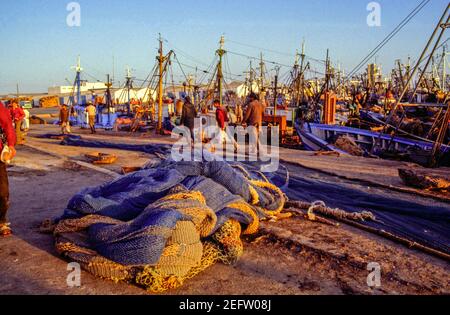 Fischerboote mit einem Haufen Fischernetze im Vordergrund im Hafen von Agadir, Marokko. Stockfoto