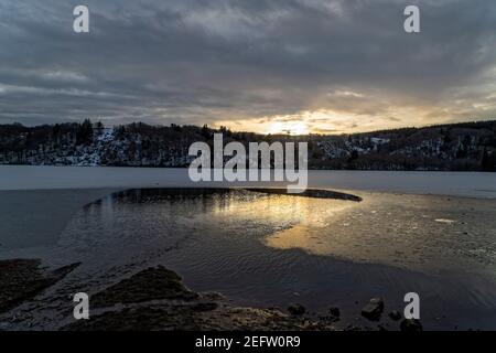 Orcival, Frankreich. Februar 2021, 15th. Lac du Guéry, umrahmt vom Banne d'Ordanche-Massiv, dem Aiguillier-Massiv und den Felsen Tuilière und Sanadoire. Stockfoto