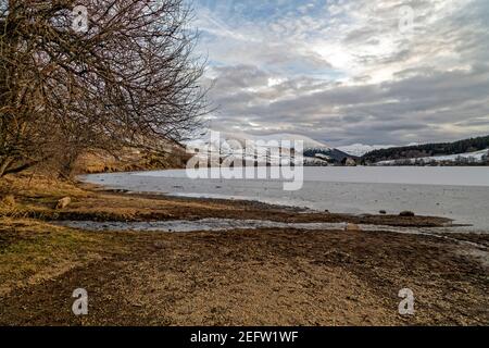 Orcival, Frankreich. Februar 2021, 15th. Lac du Guéry, umrahmt vom Banne d'Ordanche-Massiv, dem Aiguillier-Massiv und den Felsen Tuilière und Sanadoire. Stockfoto