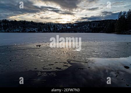 Orcival, Frankreich. Februar 2021, 15th. Lac du Guéry, umrahmt vom Banne d'Ordanche-Massiv, dem Aiguillier-Massiv und den Felsen Tuilière und Sanadoire. Stockfoto