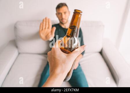 Kein Alkohol. Der junge Mann weigert sich, Bier zu trinken. Trinken Sie nicht mehr. Sagen Sie Nein zum Alkoholismus. Behandlung von Alkoholabhängigkeit Stockfoto