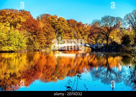 Farbenfrohe Spiegelung auf dem See mit der Bow Bridge, dem Rumble, Central Park, New York City Stockfoto