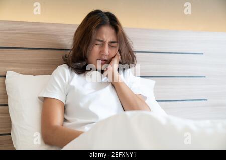 Teen Frau drückt ihre gequetscht Wange mit einem schmerzhaften Ausdruck, als ob sie eine schreckliche Zahnschmerzen. Stockfoto