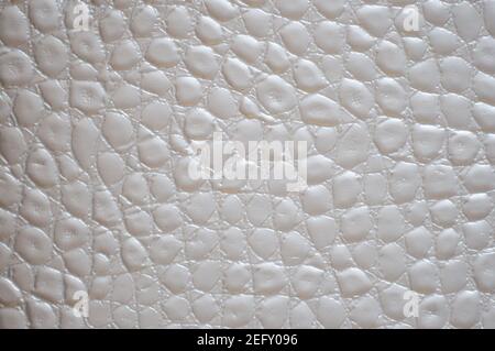 Ein Fragment aus natürlichem Leder in hellgrauer Farbe mit einem natürlichen Faltenmuster in Nahaufnahme. Hintergrund, Muster, Textur. Stockfoto
