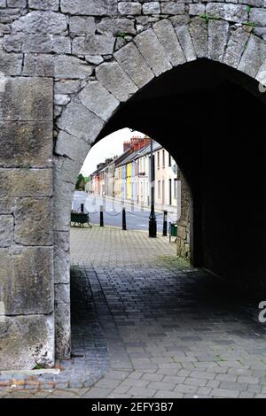 Kilmallock, County Limerick, Irland. Bunte Gebäude durch ein Portal in King John's Castle sichtbar. Stockfoto