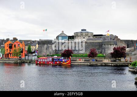 Athlone, County Westmeath, Irland. Bunte Boote, die im Fluss Shannon entlang aufgeräumter Häuser und Gebäude gefesselt sind. Stockfoto