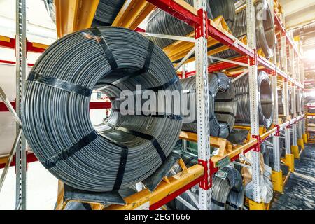 Werkseitig vorgestelltes Kabel. Drahtspulen liegen auf mehrstufigen Racks. Stockfoto