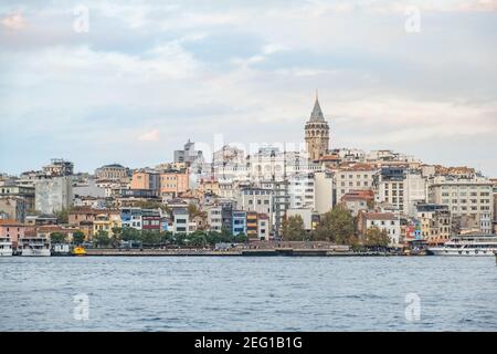 Galata-Turm und bunte Häuser neben dem Bosporus in Istanbul, Türkei - Oktober,2020: Der Galata-Turm ist einer der beliebtesten und historischen Orte. Stockfoto