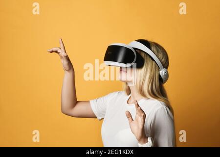 Portrait der blonden Frau in T-Shirt VR Brille Technologie Benutzer arbeiten in der virtuellen Realität. Seitenansicht Stockfoto