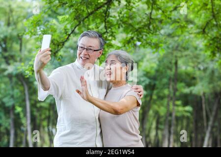 Glückliches altes Paar machen Selfie mit Handy in der parken Stockfoto