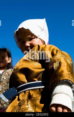 Ein süßer mongolischer Junge in seinem traditionellen Outfit. Stockfoto