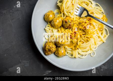 Fleischbällchen in cremiger Sauce mit Spaghetti. Selektiver Fokus. Geringe Schärfentiefe. Stockfoto
