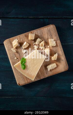 Zerbröckelter Parmesan-Käse, von oben auf einem dunklen Holzhintergrund mit Kopierfläche geschossen Stockfoto