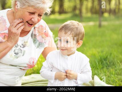 Glückliche Oma mit Enkel umarmt. Großmutter umarmt Jungen. Stockfoto