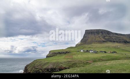 Dramatische Landschaft auf den Färöern mit Wellen, die das Ufer treffen. Die Natur der Färöer Inseln im Nordatlantik Stockfoto