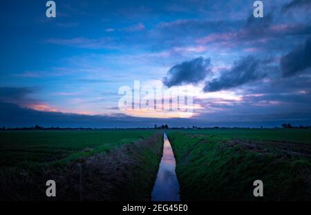 Spektakulärer Wintersonnenaufgang über flachem Ackerland Stockfoto