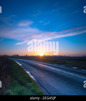 Spektakulärer Wintersonnenaufgang über flachem Ackerland Stockfoto