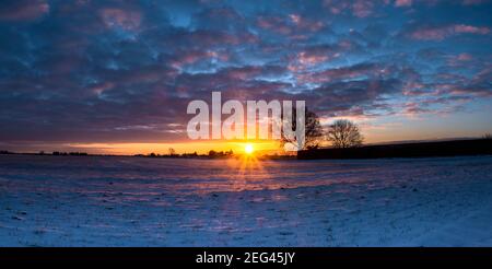 Spektakulärer Wintersonnenaufgang über flachem Ackerland Stockfoto