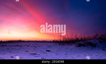 Spektakulärer Wintersonnenaufgang über flachem Ackerland Stockfoto