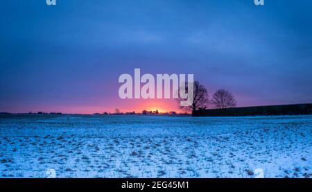 Spektakulärer Wintersonnenaufgang über flachem Ackerland Stockfoto