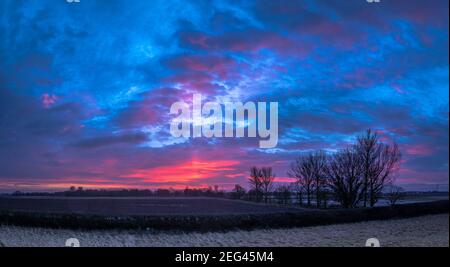Spektakulärer Wintersonnenaufgang über flachem Ackerland Stockfoto