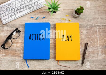 Zwei farbige Notizbücher mit der Aufschrift Aktion und Plan auf Holztisch. Geschäftliche Motivation, Management oder Inspiration. Planungskonzept. Stockfoto