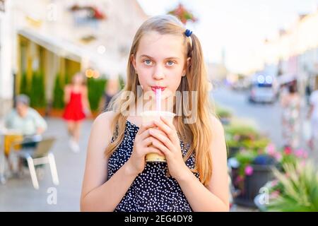 Porträt eines Teenagers, das Milchblase hält und trinkt Cocktail gekauft in einem Street Food Truck in einem sonnigen Sommertag und Blick in ein kam Stockfoto