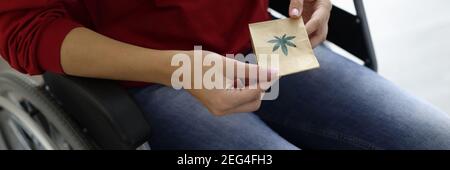 Frau im Rollstuhl hält Paket von Marihuana Nahaufnahme Stockfoto