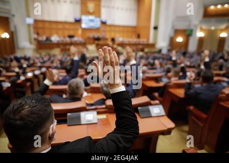 Bukarest, Rumänien - 17. Februar 2021: Geringe Schärfentiefe (selektiver Fokus) mit Details der rumänischen Parlamentsabgeordneten, die ihre Hände heben. Stockfoto