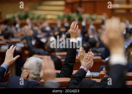 Bukarest, Rumänien - 17. Februar 2021: Geringe Schärfentiefe (selektiver Fokus) mit Details der rumänischen Parlamentsabgeordneten, die ihre Hände heben. Stockfoto