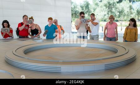 Cupertino, CA, USA - August 2019: Apple Store Cupertino mit Menschen, die Infinite Loop Apple Headquarters durch virtuelle Realität mit iPad Tab Stockfoto