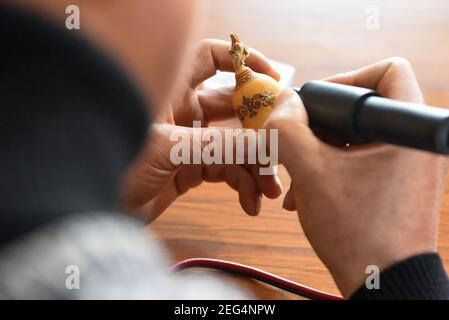 (210218) -- HORGOS, 18. Februar 2021 (Xinhua) -- Cao Guangyao arbeitet an pyrographischen Kalabash-Kunstwerken in seinem Atelier in Horgos, nordwestlich von Xinjiang Uygur Autonome Region, 6. Februar 2021. Cao Guangyao ist ein 45-jähriger Bauer in Horgos. Er ist auch bei den Einheimischen als Künstler für seine pyrographischen Kalabash-Kunstwerke bekannt. Als Maler-Enthusiast interessierte sich Cao vor 8 Jahren für pyrographische Kreation aus TV-Shows und begann seitdem seine eigene Kreation. Trotz keiner beruflichen Ausbildung, Cao machte Kunst Versuche immer wieder mit Liebe und Leidenschaft während der Lacksaison der Landwirtschaft Stockfoto